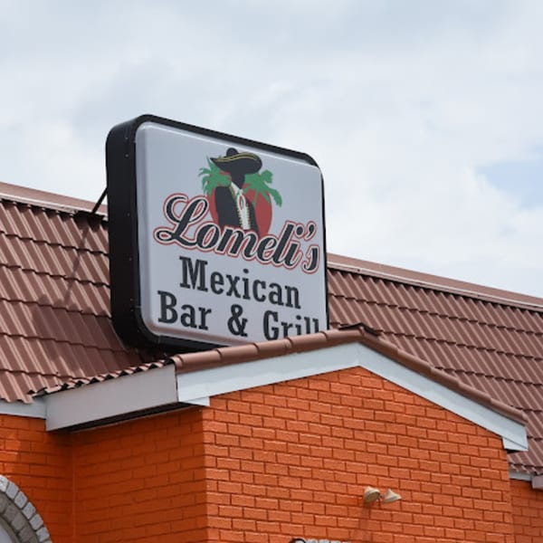 Lomeli's Mexican Bar & Grill sign on an orange brick building with a brown tiled roof.