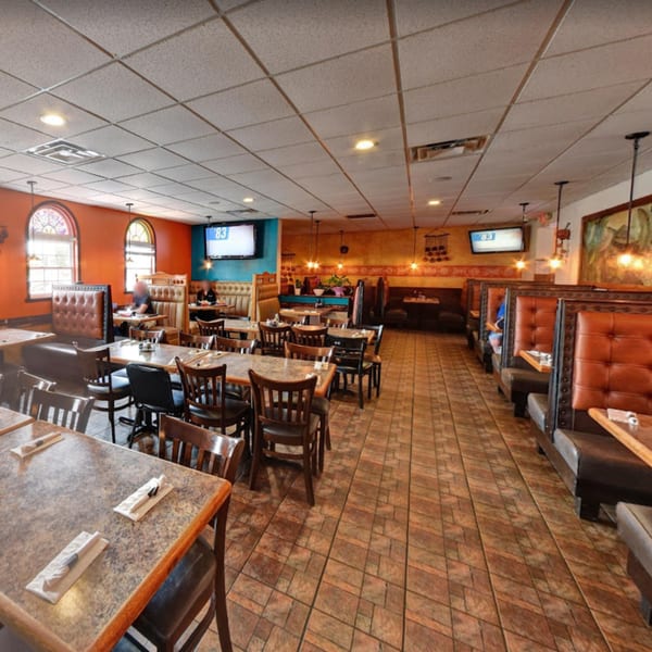 Spacious dining room at Lomeli's Mexican Bar and Grill with booths, tables, and warm lighting.