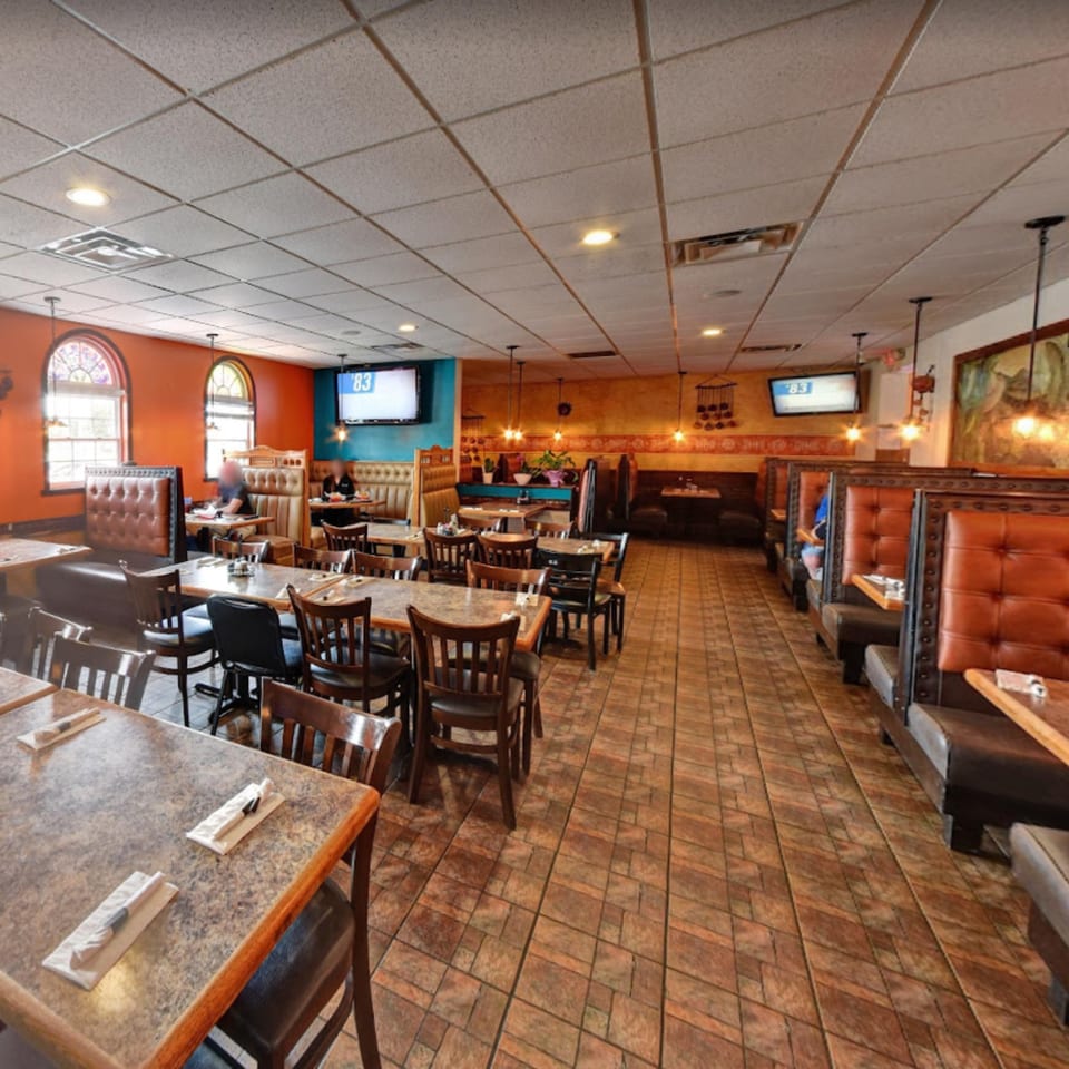 Spacious dining room at Lomeli's Mexican Bar and Grill with booths, tables, and warm lighting.