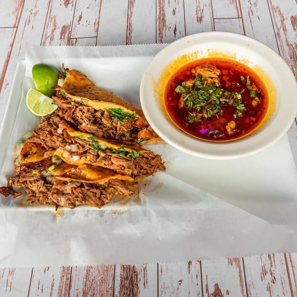 Lomeli's Mexican Bar and Grill birria tacos with limes and a side of consommé.