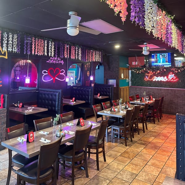 Lomeli's Mexican Bar and Grill dining room with tables, booths, and neon signs.