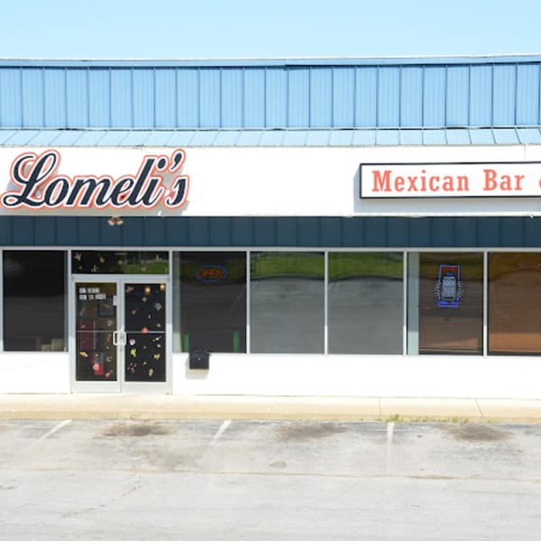 Exterior of Lomeli's Mexican Bar and Grill, a white building with a blue roof and large windows.