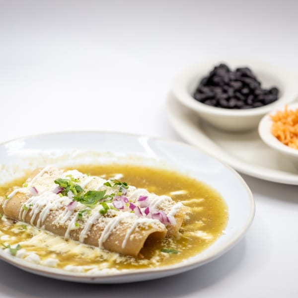 Lomeli's Mexican Bar and Grill enchiladas with green sauce, cheese, onions, cilantro, and sides.